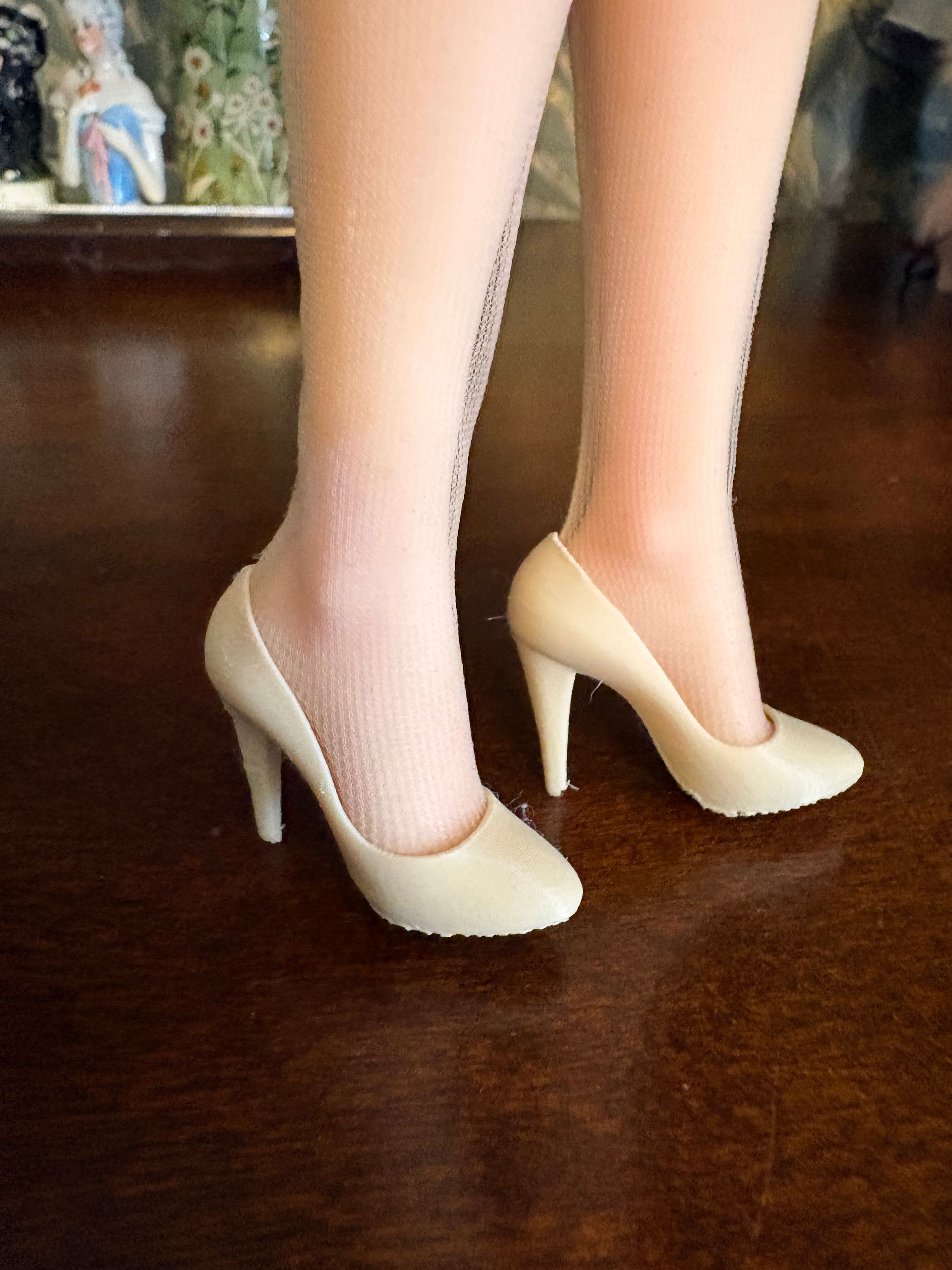 A pair of white 3D printed high-heel shoes, worn
