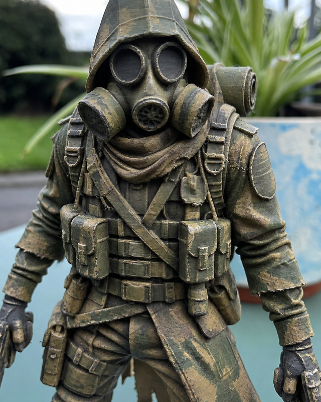 Painted 3D printed figurine of a soldier in a gas mask and long coat